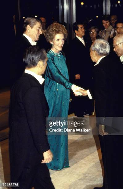 Japanese Emperor Hirohito greeting Nancy Reagan and President Ronald Reagan upon arrival at the white tie dinner at the Imperial Palace.