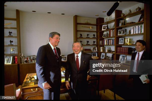 Former US President Ronald Reagan standing in his new Century City office with Japanese PM Noboru Takeshita.