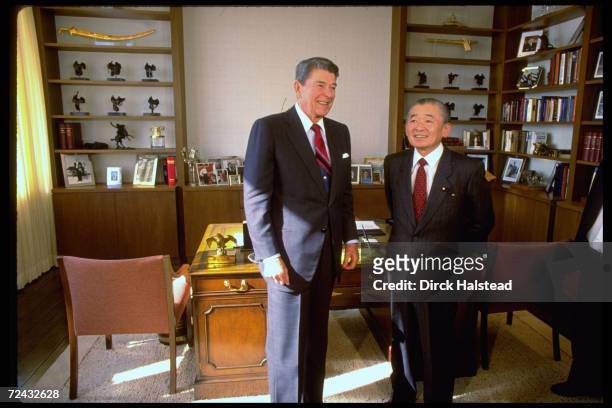 Former US President Ronald Reagan standing in his new Century City office with Japanese PM Noboru Takeshita.
