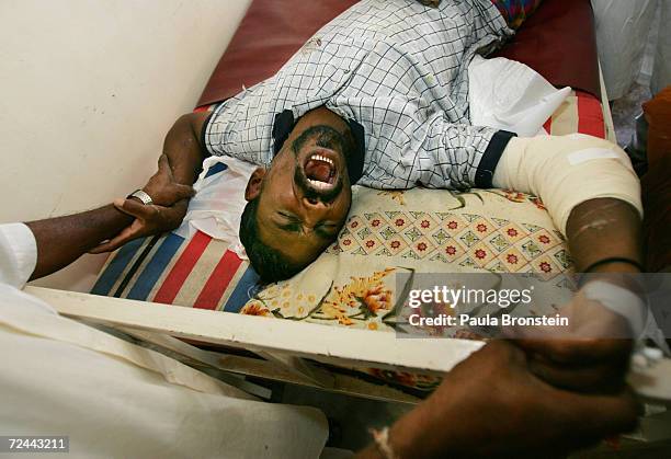 Pedropullai Peter, a tsunami earthquake victim, screams in pain as he gets medical care for his wounds by the Korean Disaster Medical Assistance team...