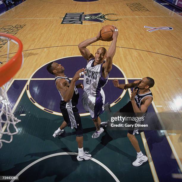 Forward Darvin Ham of the Milwaukee Bucks shoots the ball over two San Antonio Spurs - center David Robinson and guard Steve Smith - during the NBA...