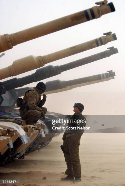 Marine Corps 1st Tank Battalion tank crews wait out a sand storm during an exercise February 3, 2003 near the Iraqi border in Kuwait. Both Marine and...