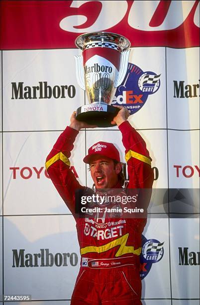 Jimmy Vasser of Team Target/Chip Gnassi and driver of the Reynard Honda 98I holds the trophy following the CART Marlboro 500 at the California...