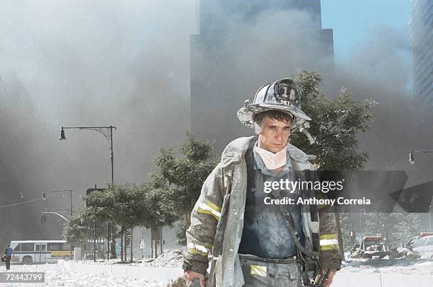 An unidentified New York City firefighter walks away from Ground Zero after the collapse of the Twin Towers September 11, 2001 in New York City. The...