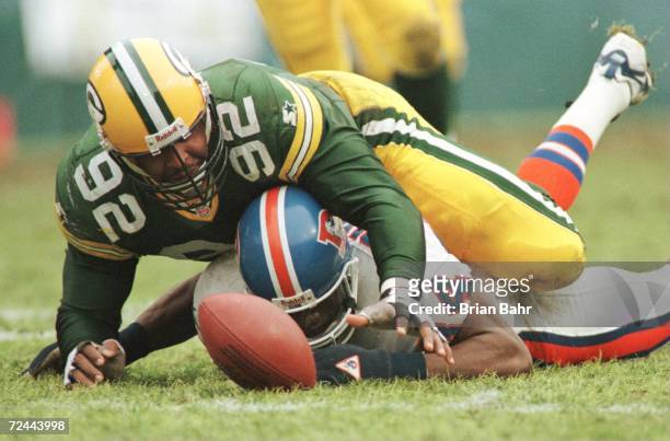 Defensive end Reggie White of the Green Bay Packers scrambles over wide receiver Shannon Sharpe of the Denver Broncos for quarterback Bill...