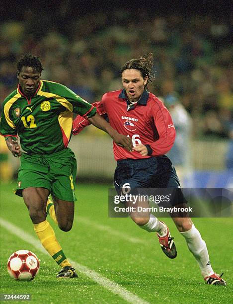 Lauren of Cameroon is put under pressure by Rafael Olarra of Chile during the Mens Football Semi-Final at the MCG in Melbourne on Day 11 of the...