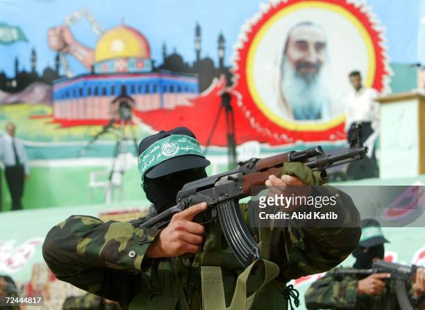 Armed Palestinians from the military wing of the Islamic resistance movement, Hamas, wield their AK-47 rifles, as they demonstrate martial arts...