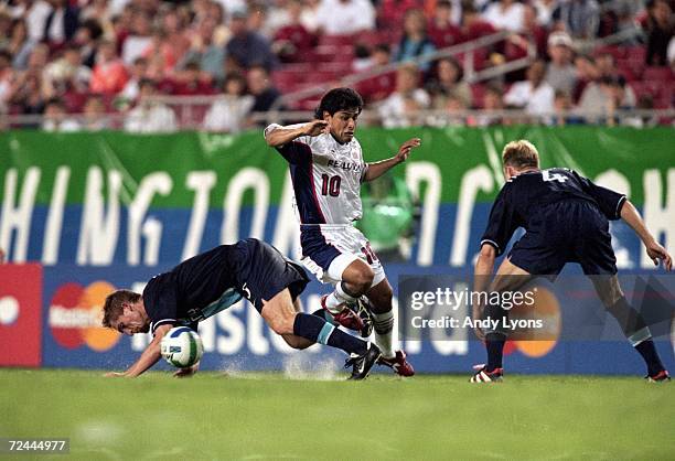 Mauricio Ramos of the New England Revolution trips over a player for the Tampa Bay Mutiny at the Raymond James Stadium in Tampa, Florida. The Mutiny...