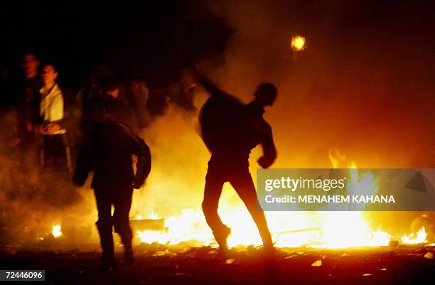 Ultra Orthodox Jewish demonstrators set up burning road blocks and throw stones during a protest in Jerusalem, early 08 November 2006, against...
