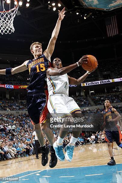 Chris Paul of the New Orleans/Oklahoma City Hornets attempts to shoot a layup against Andris Biedrins of the Golden State Warriors on November 7,...