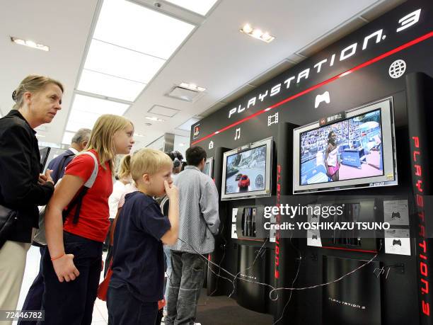 Customers try to use Sony Computer Entertainment's new video game console PlayStation 3 , which will be launched this weekend, at the company's...