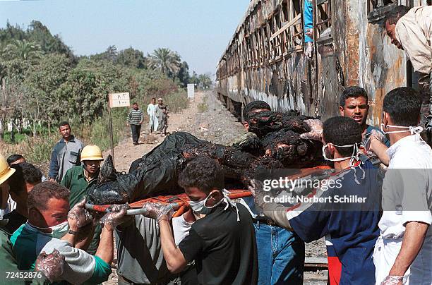 Rescue workers recover bodies from inside the train that caught fire February 20, 2002 while heading south, from Cairo, Egypt for the Islamic...