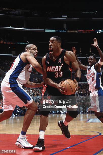 Center Alonzo Mourning of the Miami Heat holds the ball as center Sean Rooks of the Los Angeles Clippers plays defense during the NBA game at the...