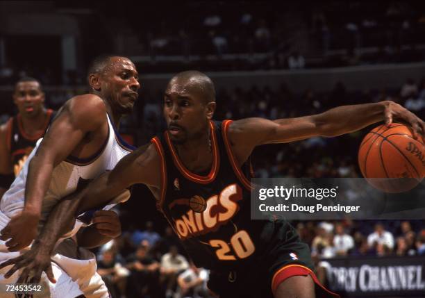 Gary Payton of the Seattle SuperSonics takes the ball to the basket as he is blocked by Chris Whitney of the Washington Wizards at the MCI Center in...