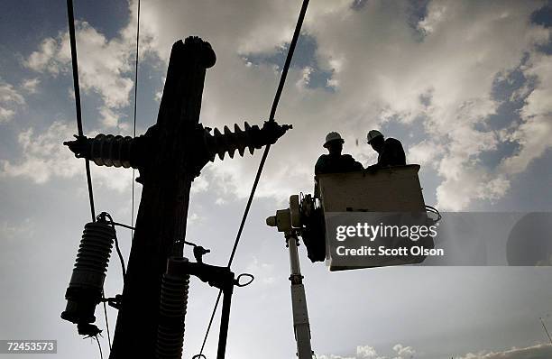 Linemen from Illinois work on resetting a power pole sheared into three pieces by Hurricane Ivan September 19, 2004 in Pensacola, Florida. Linemen...