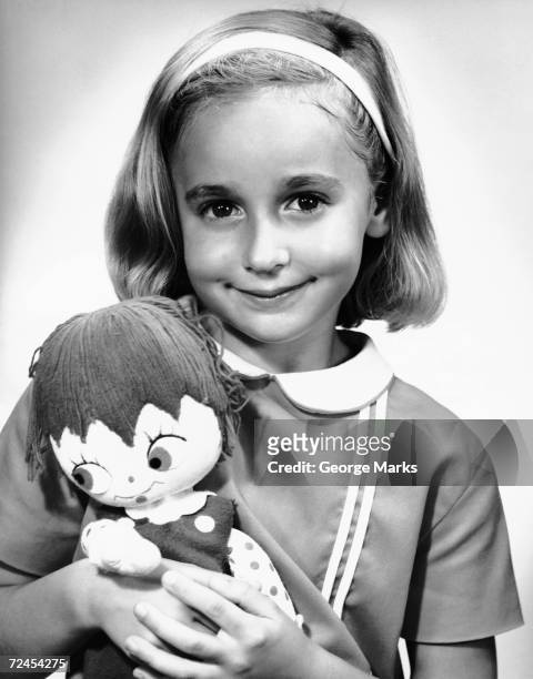 1950s: Portrait of girl indoor with doll.