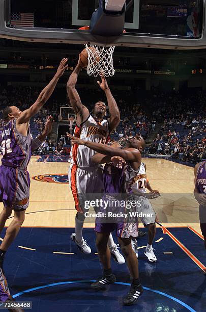 Center Erick Dampier of the Golden State Warriors shoots over forward Alton Ford of the Phoenix Suns during the NBA game at the Arena in Oakland in...