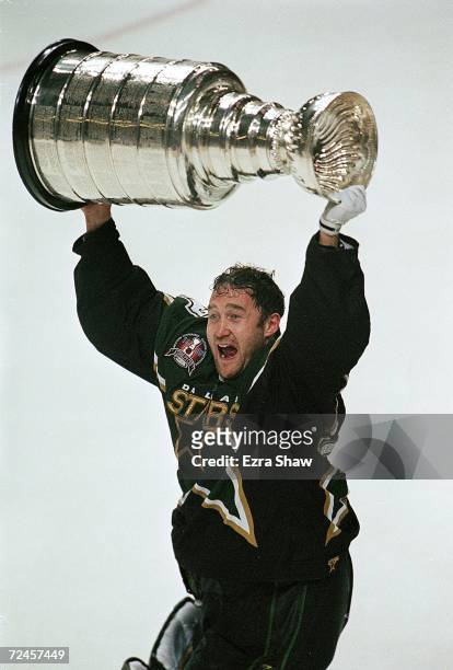 Ed Belfour of the Dallas Stars celebrates as he carries the Stanely Cup on the ice after the Stanley Cup Game against the Buffalo Sabres at the...