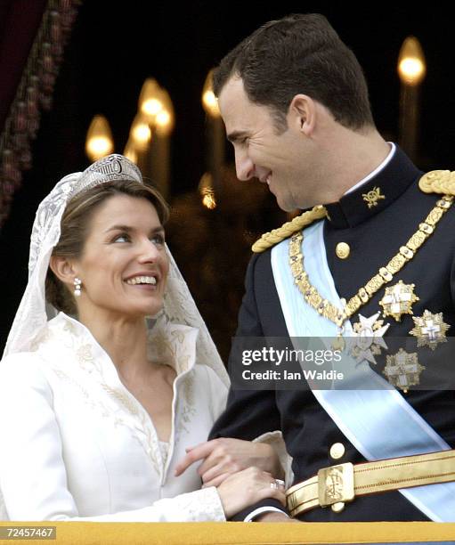 Spanish Crown Prince Felipe de Bourbon and his bride Letizia look at each other as the Royal couple appears on the balcony of Royal Palace May 22,...
