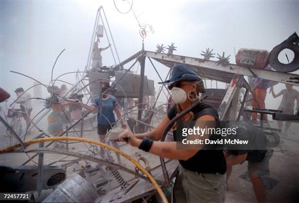 People drum on a percussion junk pile despite a blinding dust storm caused by strong winds September 2, 2000 at the 15th annual Burning Man festival...