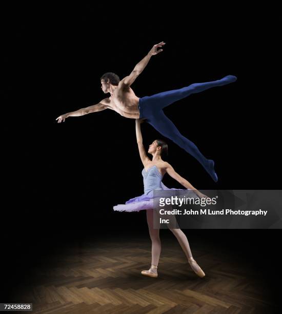 female ballet dancer holding up male ballet dancer - rolwisseling stockfoto's en -beelden