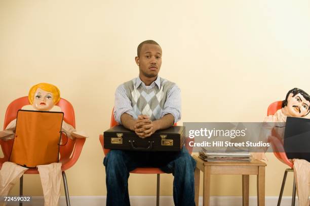 african man with briefcase in waiting area next to blowup dolls - blow up doll 個照片及圖片檔