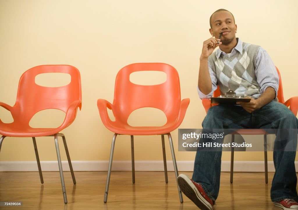 African man filling out form in waiting area