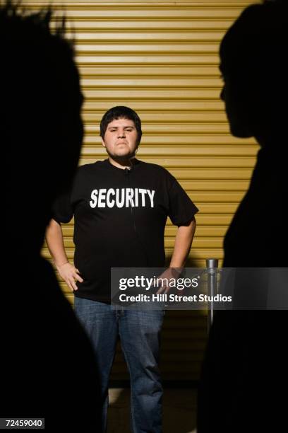 man wearing security shirt with hands on hips - bouncer guarding stock pictures, royalty-free photos & images