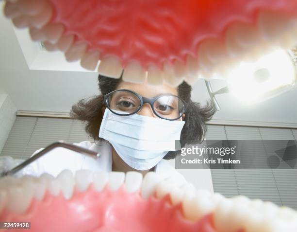 shot from mouth looking out at african female dentist - funny surgical masks stockfoto's en -beelden