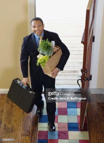 african businessman arriving at home with groceries - homecoming 個照片及圖片檔
