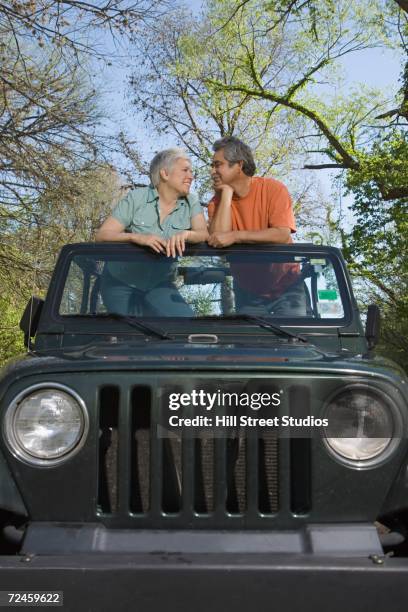 senior hispanic couple standing in jeep - grille stock pictures, royalty-free photos & images