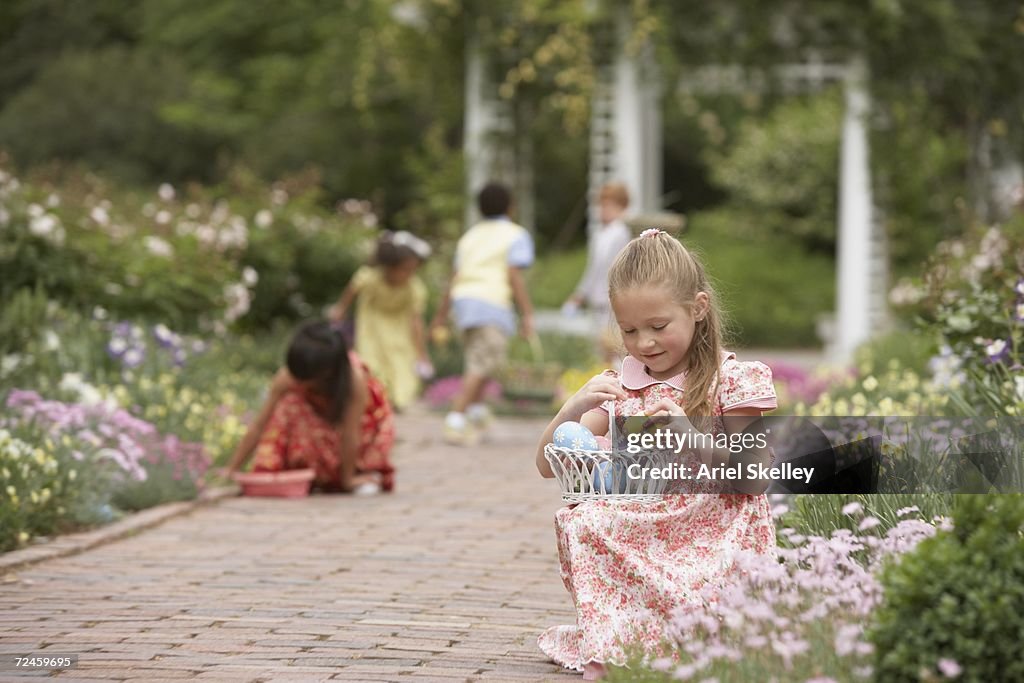 Children gathering Easter eggs in garden