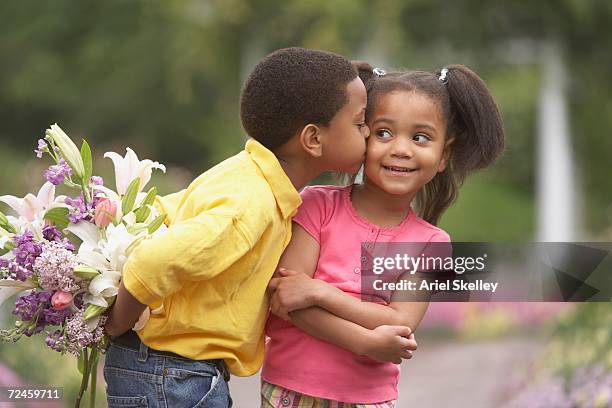 young african boy kissing young african girl on cheek - awkward date stock-fotos und bilder
