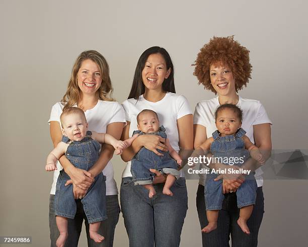 three young mothers holding babies in overalls - jeans latzhose frau stock-fotos und bilder