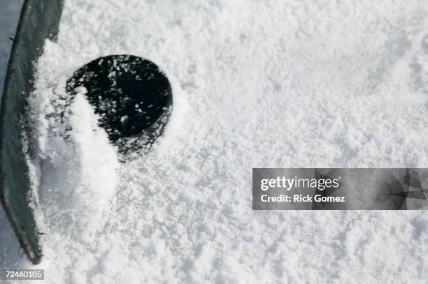 close up of hockey stick and puck on ice - ijshockeystick stockfoto's en -beelden