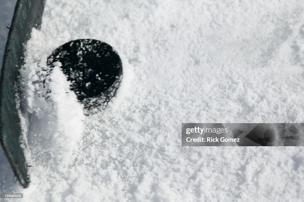 Close up of hockey stick and puck on ice