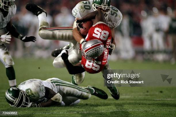 Tight end John Lumpkin of the Ohio State Buckeyes is tackled by Josh Thornhill of the Michigan State Spartans during a game at the Ohio Stadium in...