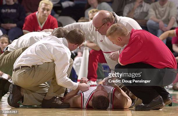 Coach Rick Majerus, center, of the University of Utah and his staff attend to Jeremy Killion who went down in the second half as they defeated Saint...