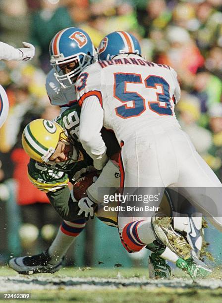 Antonio Freeman of the Green Bay Packers is brought down by Bill Romanowski of the Denver Broncos after pulling in a catch during the first half of...