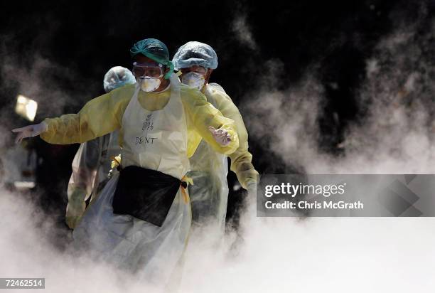 Medical workers walk through dry ice vapour at a makeshift morgue inside a Buddhist temple on January 2, 2005 in Takuapa, Thailand. The bloated and...