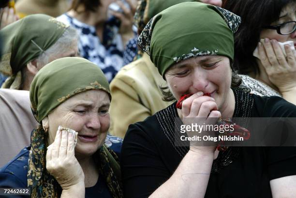 Russian women cry during the funeral of sisters Irina and Alina Tetova September 5, 2004 in Beslan, Russia. The girls were killed after Chechen...