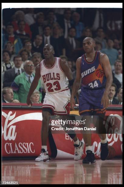 Guard Michael Jordan of the Chicago Bulls and forward Charles Barkley of the Phoenix Suns walk down the court during a game at the United Center in...