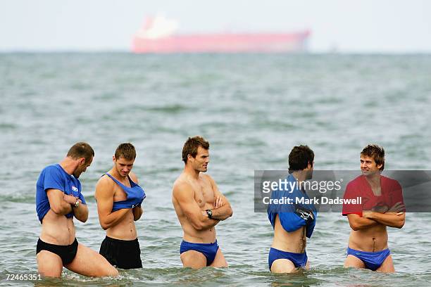 Chris Grant, Tim Walsh, Luke Darcy, Kieran McGuinness and Adam Morgan wade through the water during the Western Bulldogs AFL recovery session at the...