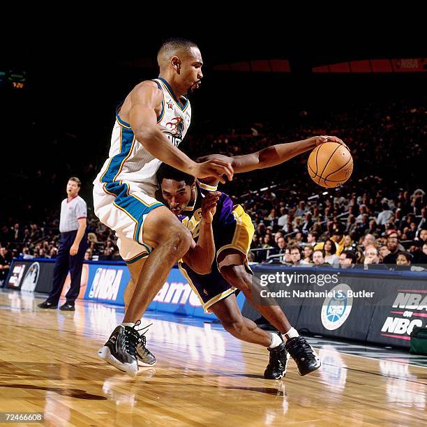 Kobe Bryant of the Western Conference All-Stars drives to the basket against Grant Hill of the Eastern Conference All-Stars during the 1998 NBA...