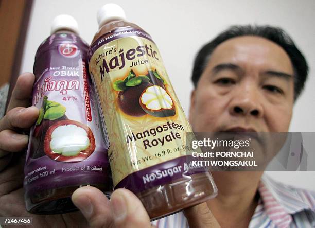Manager of the Thai company Buathanuth, Rojanin Sretputtiporn, shows bottles of mangosteen juice at his factory in Bangkok, 09 November 2006. Thais...