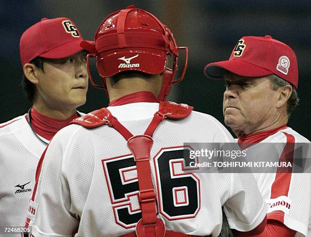 China Stars team manager Jim Lafebvre from the US speaks with a starter Chen Haifeng and a catcher Wang Wei during the fifth inning of the match...