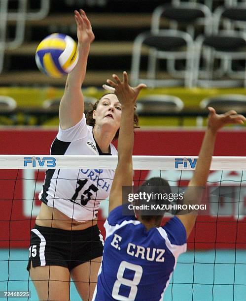 German Angelina Grun spikes the ball past Puerto Rican blocker Eva Cruz during their pool F second round match of the women's volleyball world...