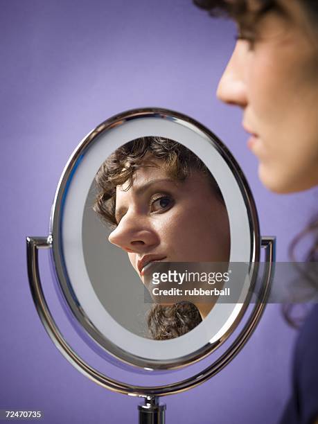 close-up of a young woman looking into a mirror - big nose stock-fotos und bilder