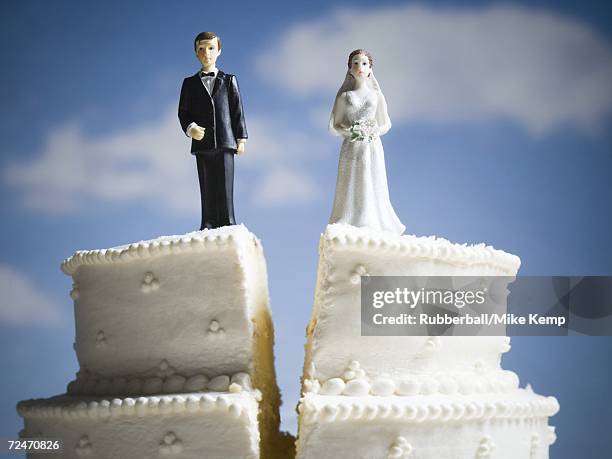 wedding cake visual metaphor with figurine cake toppers - scheidung stock-fotos und bilder