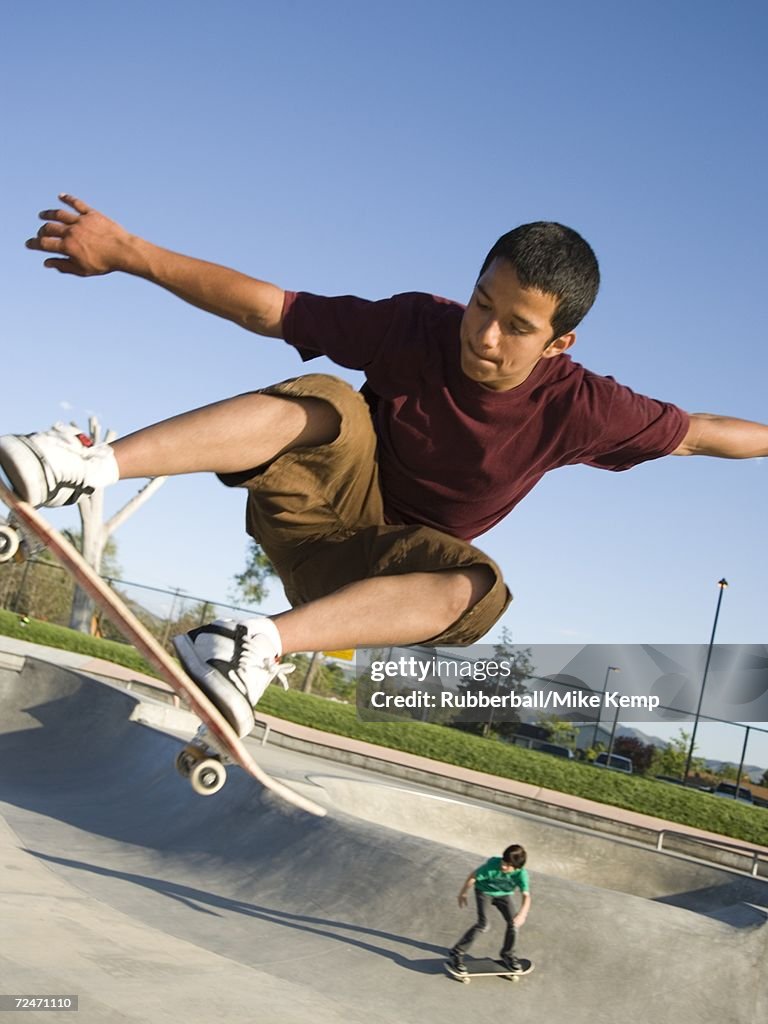 Teenage boy jumping with a skateboard
